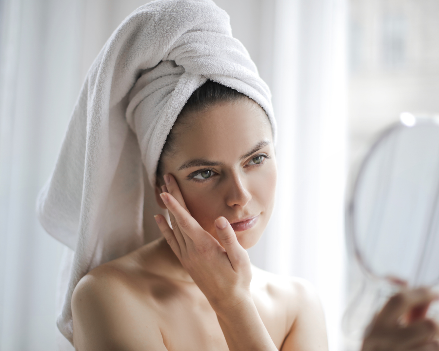 Photo of woman applying skin care cream.