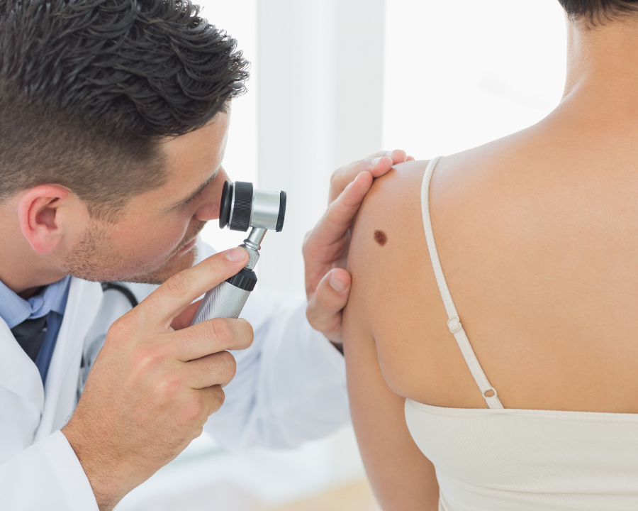 Doctor inspecting skin for signs of skin cancer.